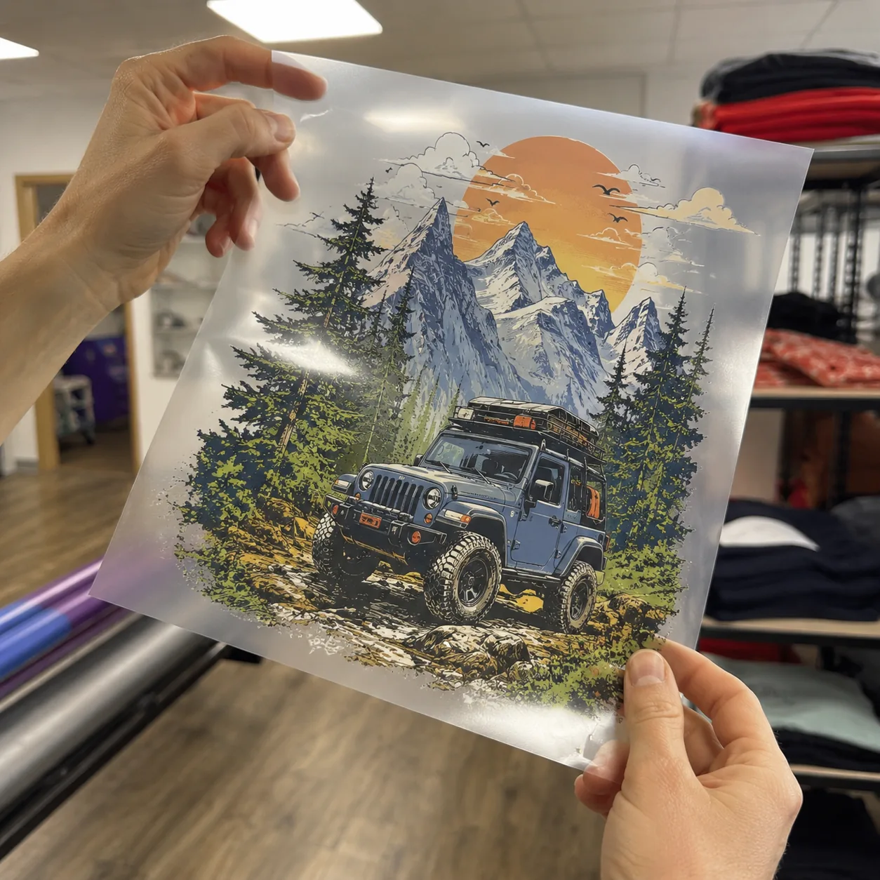 A freshly printed DTF transfer held up to the light to inspect